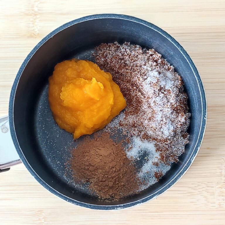 Pureed pumpkin, dark brown sugar, fine white sugar and spices mixture in a shallow black pan