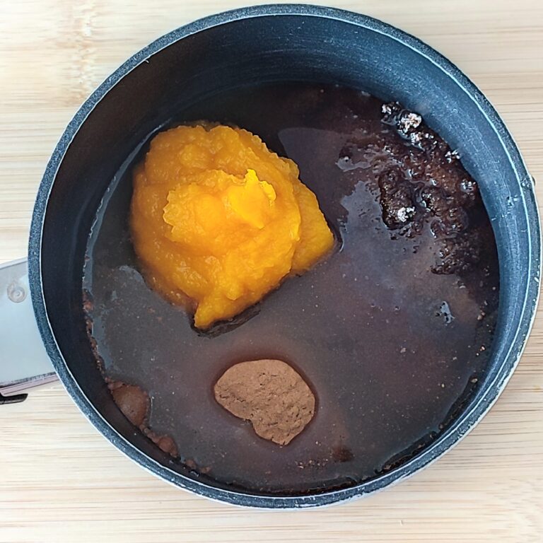 Add water to pureed pumpkin, dark brown sugar, fine white sugar and spices mixture in a shallow black pan