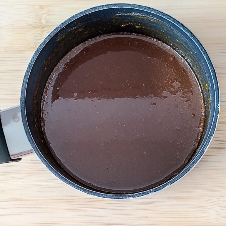 Cooked pumpkin spice syrup in a shallow black pan