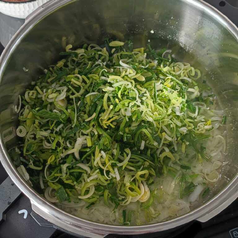 Adding finely sliced leeks to the pot