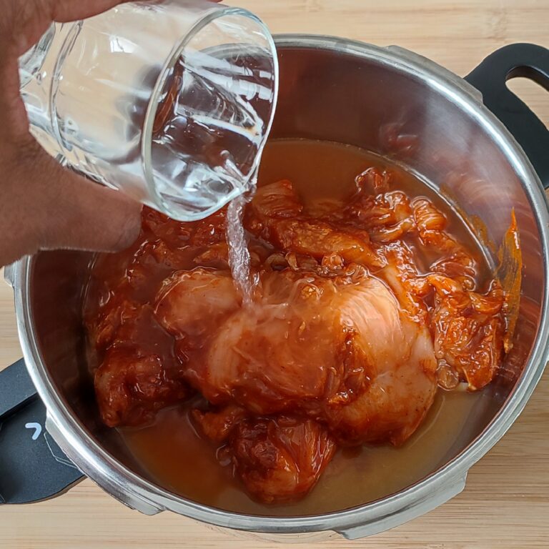 Added water to the chicken breast fillet evenly coated with all of the spices, sauce, sugar and oil in a pressure cooker