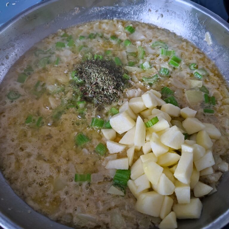 Adding apple pieces and herb mix to the base in a large skillet