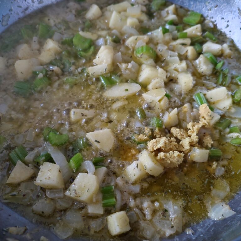 Adding crushed chicken stock cube to the base in a large skillet