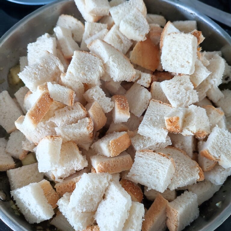 Adding prepped bread to the base in a large skillet