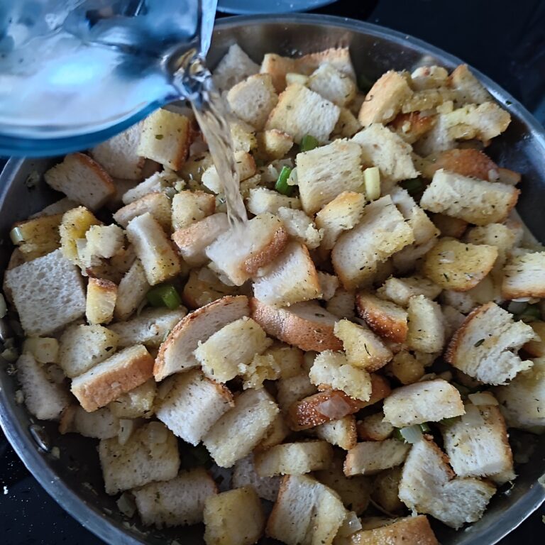 Adding water to the stuffing base mix in a large skillet