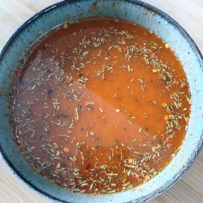 Added melted butter to the herb butter mix in a wide blue bowl