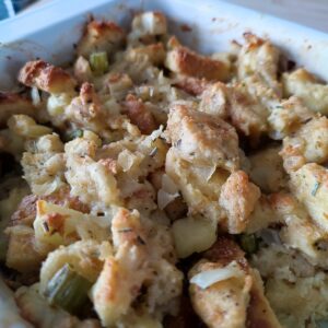 A closeup shot of Easy Christmas Buttery Apple Herb Stuffing in a white coloured rectangular casserole dish