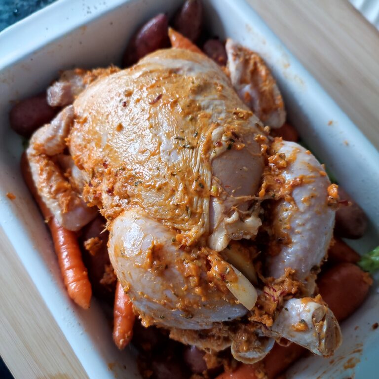 Prepping the Chicken with carrots and potatoes in a white rectangular casserole dish before baking