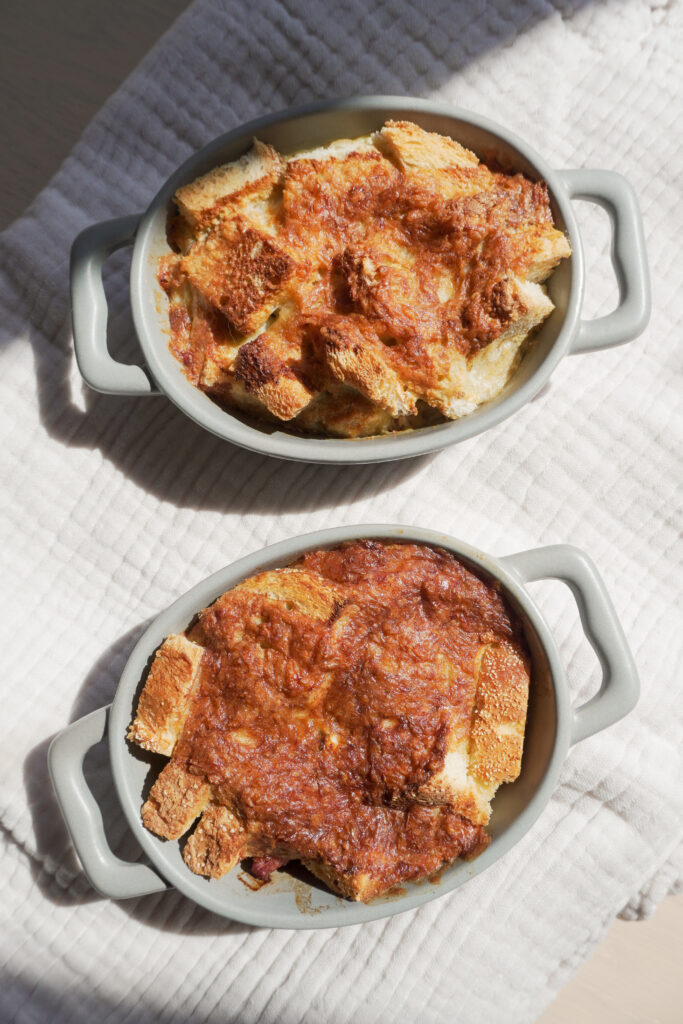 Breakfast Strata in two mini casserole dish on cream coloured textured cloth top view
