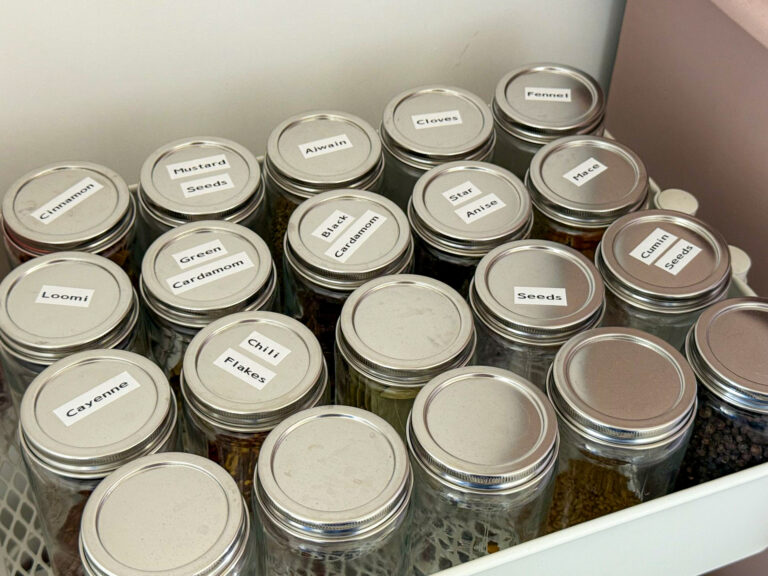 Labeled spice bottles on a spice open moving storage