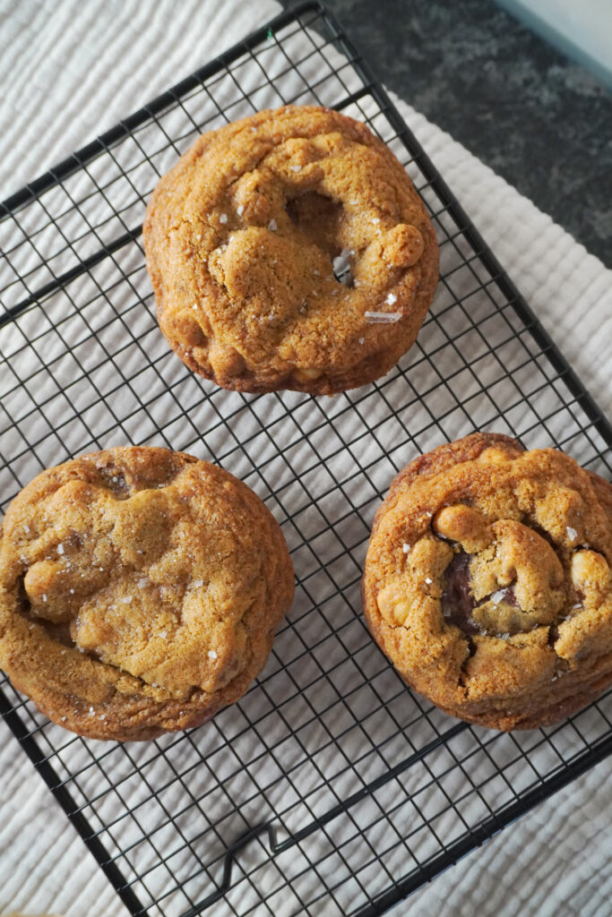B roll 2: Three Nutella Cardamom Chocolate Chip Cookies cooling on a black wire rack