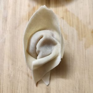 Raw boat shaped potsticker on a working surface