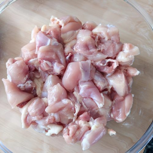 Boneless chicken thighs pieces in a large bowl on a work surface