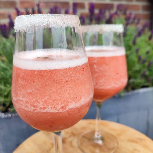 Frosé Punch ready to be serve in wine glasses with the background of lavender flowers