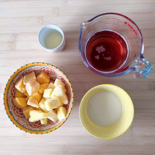 Ingredients for Rosé Mango Piña Colada on a working surface