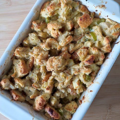 Baked and ready to serve Christmas Buttery Apple Herb Stuffing in a white coloured rectangular casserole dish