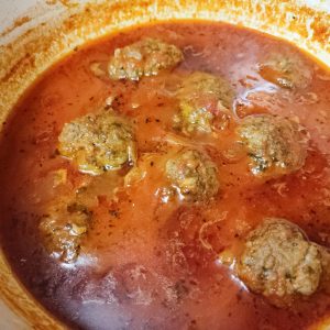 Cooked polpette in a tomato based sauce