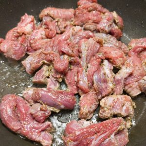 Browning the sirloin steak in a pan