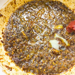 Adding ghee and tomato paste to the rest in a casserole pan