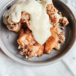 Peach Crumble with custard topping on a dessert plate